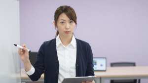 コワーキングスペースでプレゼンする女性