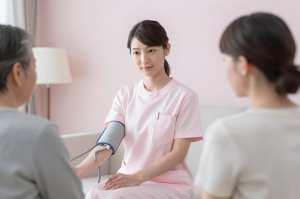 訪問看護で血圧測定する看護師