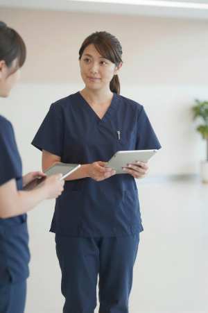 病院ロビーでタブレット操作する医師