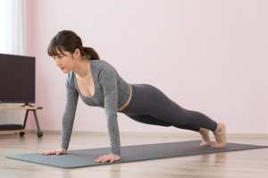 自宅リビングでプランクに励む女性