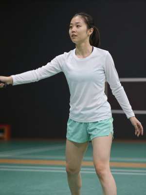 体育館でバドミントンを楽しむ女性