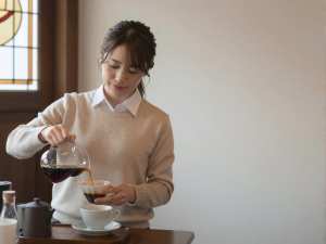 レトロな喫茶店でコーヒーを淹れる女性