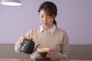 カフェでハンドドリップコーヒーを淹れる女性