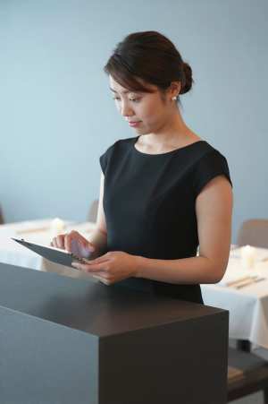 高級レストランで予約を確認する女性