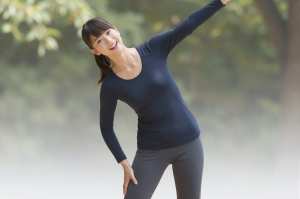 公園でストレッチするリラックスした女性