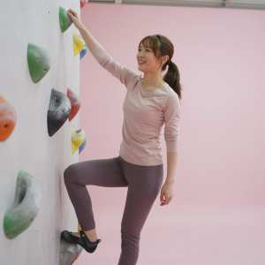 ボルダリングジムで壁を下る女性