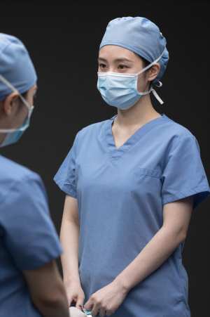 手術室で器具を渡す外科医