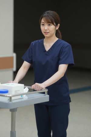 病院廊下でカートを押す看護師