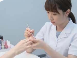 ネイルスタジオで施術中のネイリスト
