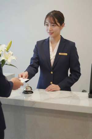 ホテルロビーで客を迎える女性スタッフ