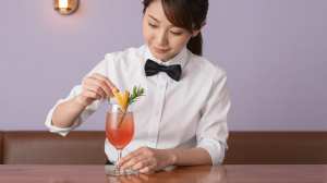 バーでカクテルを丁寧に飾るバーテンダー