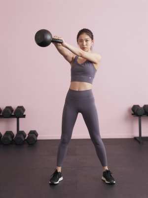 力強くケトルベルスイングをする女性