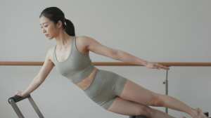 ピラティスリフォーマーで体幹を鍛える女性