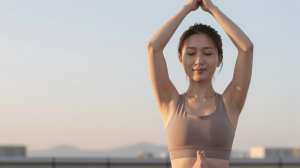 朝日で輝く木のポーズの女性