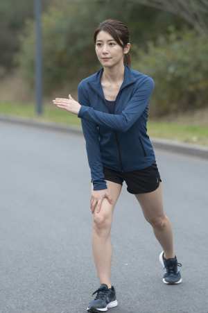 屋外でダイナミックストレッチをする男性