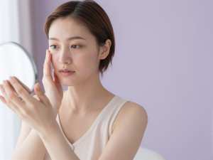 鏡で肌の調子を確認する女性