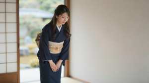 旅館で客を迎える着物姿の女性