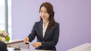 ホテル受付で鍵を渡す女性