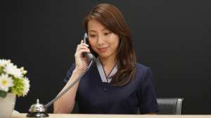 ホテルで電話対応する女性