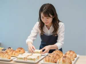 カフェでフードを並べるバリスタ