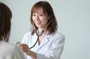 患者の心音を聞く女医