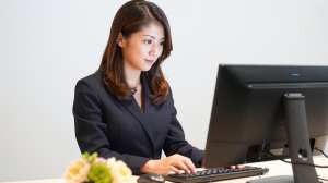 ホテル受付でPCを操作する女性