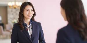 ホテルロビーで客を迎える女性