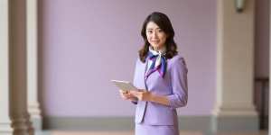 ホテルのエントランスで客を迎える女性