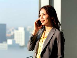 窓際で電話するビジネス女性