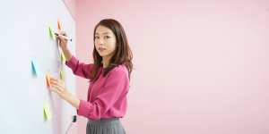 ホワイトボードで指導する女性