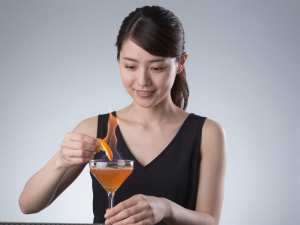 カクテルに火を灯すバーテンダー