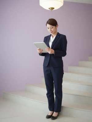 ホテルロビーでタブレットを確認する女性