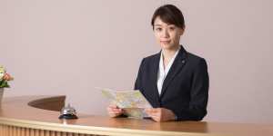 笑顔で案内するホテルコンシェルジュ