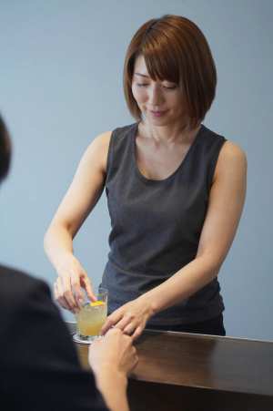 お客様にドリンクを提供するバーテンダー