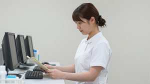 ナースステーションで業務中の看護師