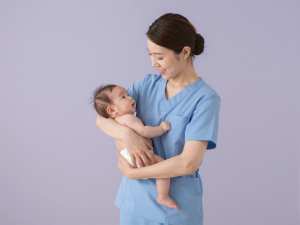 赤ちゃんを抱く優しい看護師