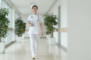 病院の廊下を歩くベテラン看護師