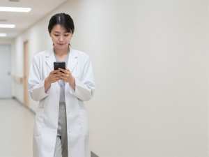 スマートフォンを見る女性医師
