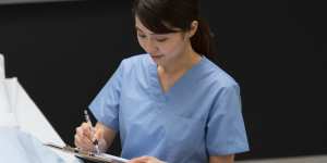 バイタルを記録する看護師