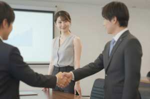 会議室で握手するビジネスパーソン