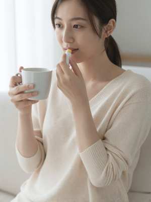 リビングでリップケアをする女性