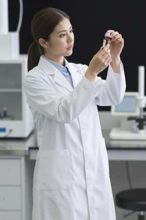 研究所でエッセンシャルオイルを検査する女性研究員