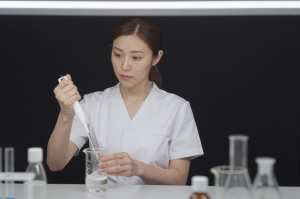 ラボで美容成分を計量する女性研究員