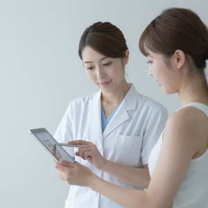 皮膚科で肌の状態を説明する医師