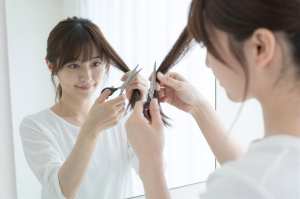 自宅で髪の毛をセルフカットする女性