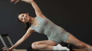 ピラティススティックでサイドベンドをする女性