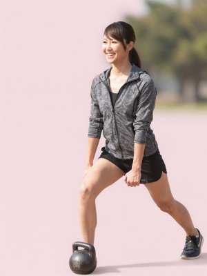 公園でケトルベルランジをする男性