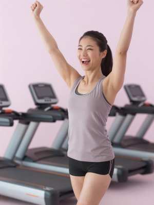 トレッドミルで個人ベストを達成し喜ぶ女性の顔