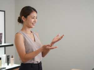 美容カウンターで商品を説明する女性