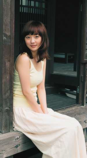 和風建築の木造デッキに座る若き女性の優雅なポートレート